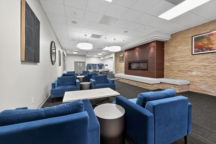 Elegant lounge featuring modern blue seating, stylish decor, and warm wood paneling, perfect for relaxation and socializing.