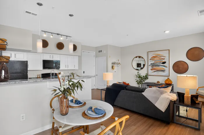 Modern open-concept living and dining area with chic decor, cozy seating, and a stylish kitchen in the background.