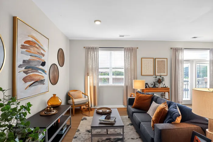 Inviting and stylish living room with a cozy sofa, modern decor, and natural lighting through large windows.