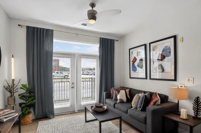 Bright and modern living room featuring a stylish sofa, elegant decor, and large windows with scenic views.