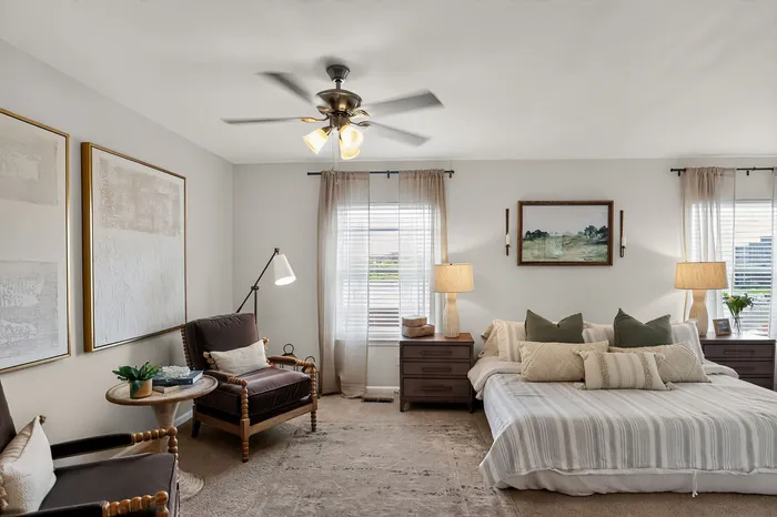 Inviting bedroom with elegant decor, featuring a cozy bed, stylish armchairs, and warm ambient lighting.
