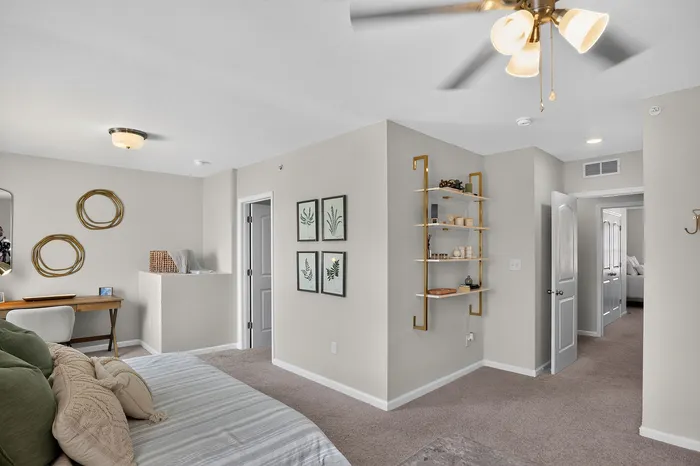Charming bedroom with elegant decor, featuring a cozy bed, stylish artwork, and a sleek desk for a serene living space.
