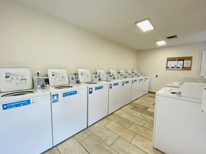 View of the laundry room showing multiple washers and an open floor plan, designed for easy access and efficient use.