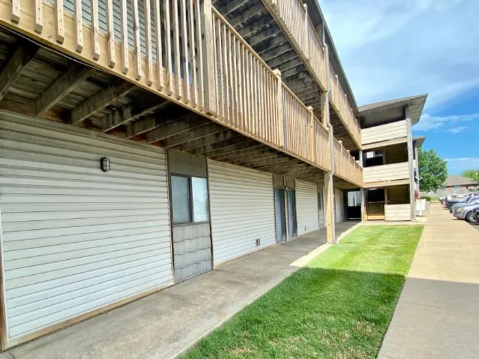 Side angle of a multi-story building at Fremont Landing, showing private patios on the ground level and upper wooden balconies above.