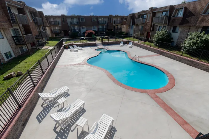 Aerial-style view of the pool area at Seminole Apartments showing surrounding buildings and seating area.