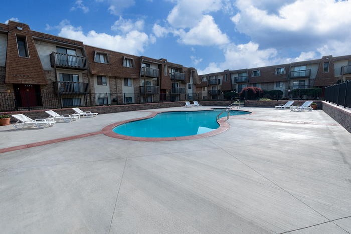 Ground-level perspective of the Seminole Apartments pool, showcasing red trim and clean concrete decking.
