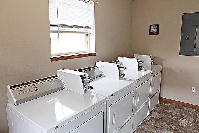 On-site laundry room at Lakewood Village in Springfield, MO, featuring multiple coin-operated washers and dryers in a clean, well-lit space.
