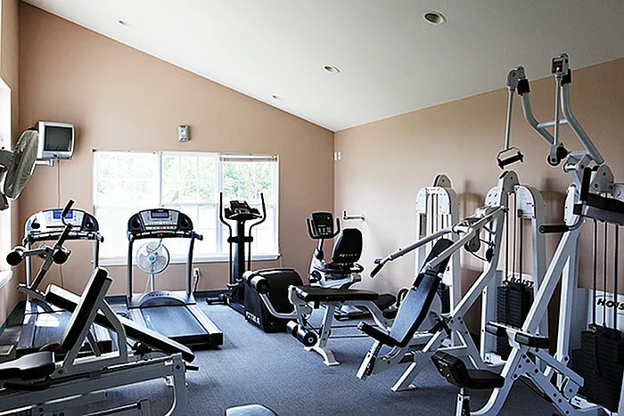 On-site fitness center at Lakewood Village Apartments in Springfield, MO, featuring cardio machines, weight training equipment, and natural lighting for a convenient resident workout space.