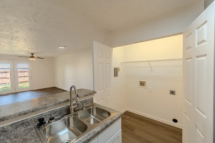 Laundry closet with full-size washer and dryer hookups located conveniently off the kitchen area.
