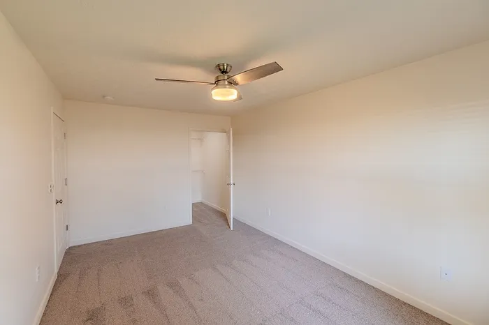 View of the bedroom entry and spacious walk-in closet in a renovated 1-bedroom apartment home.