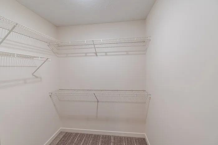 Walk-in closet with built-in wire shelving for efficient storage in a Battlefield, MO 1-bedroom apartment.