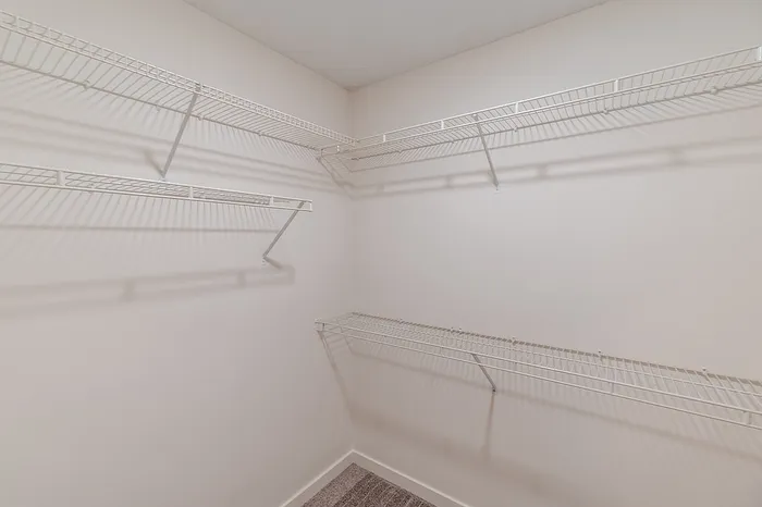 Spacious walk-in closet with built-in wire shelving, perfect for organized storage in a renovated 1-bedroom apartment in Battlefield, MO.