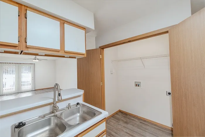 Chic kitchen space featuring modern dual sinks, elegant cabinetry, and a bright open layout with a view to the living room.