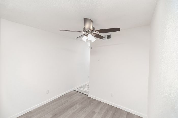 Modern Dining room with sleek ceiling fan and elegant hardwood flooring, showcasing minimalistic design and bright ambiance.