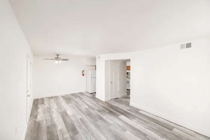 Living room with vinyl plank flooring, ceiling fan, and open layout at Lombard Heights Apartments.