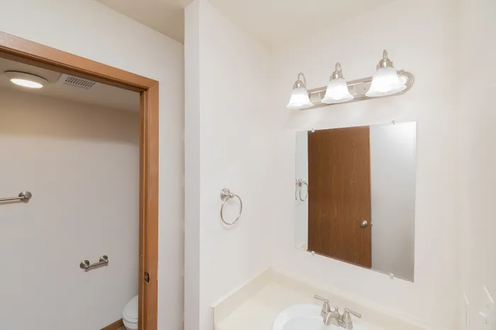 Modern bathroom featuring elegant lighting, a stylish mirror, and a sleek sink design.