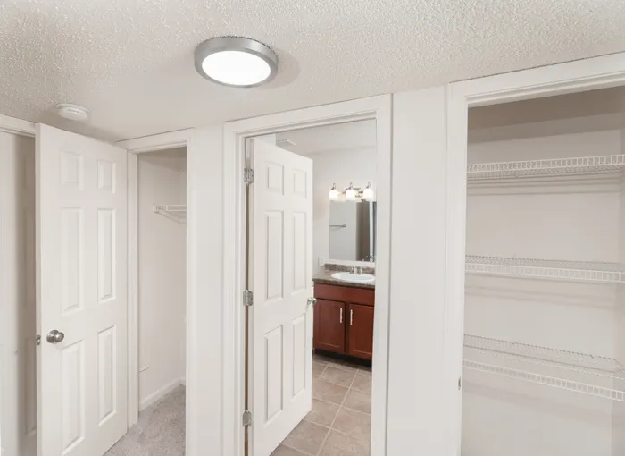 Hallway that looks into Bathroom with nearby closet space at Quail Ridge East Apartments.