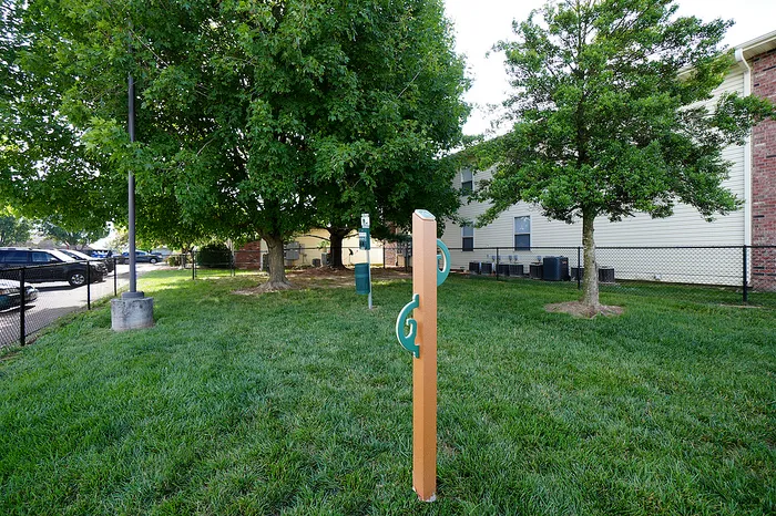 Charming and pet-friendly outdoor space with lush greenery, bench seating, and convenient pet waste station, ideal for relaxation and leisure.