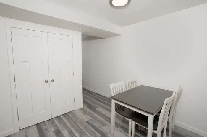 Dining area with wood style flooring, white walls, overhead lighting, and space for table seating in Dryden Place Townhomes