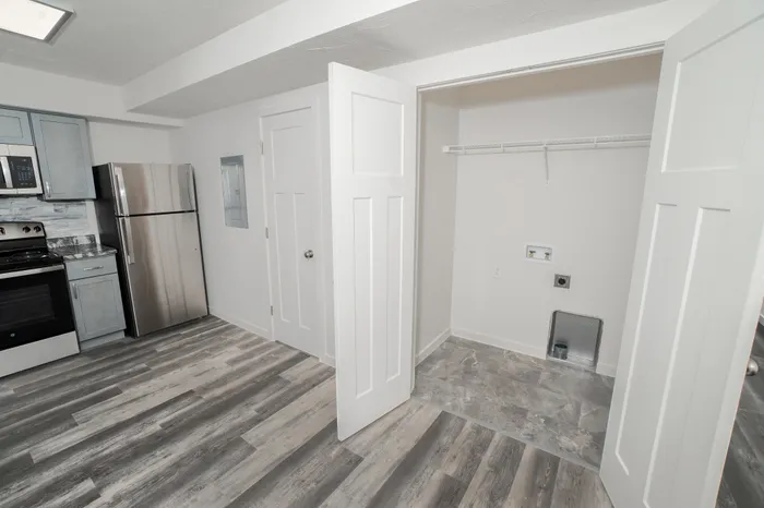 Laundry area with washer dryer hookups, shelving, and utility space in Dryden Place Townhomes