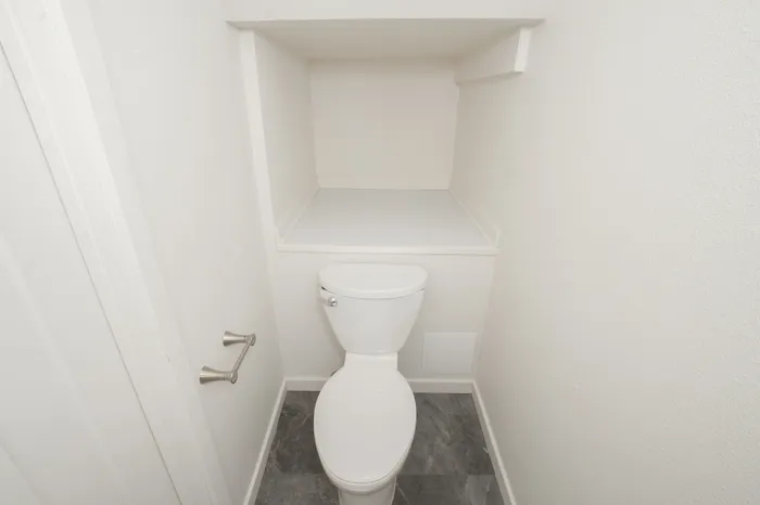 Half bathroom with toilet, built in shelving, and neutral finishes in Dryden Place Townhomes
