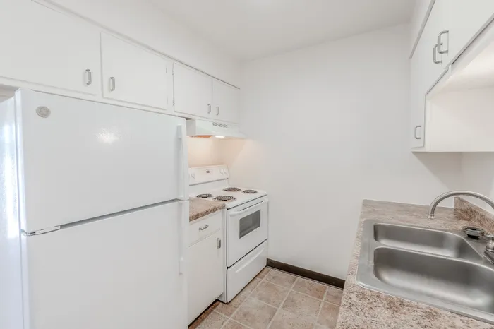 Kitchen in the Classic 1 Bedroom layout with a double sink, laminate countertops, and overhead lighting.