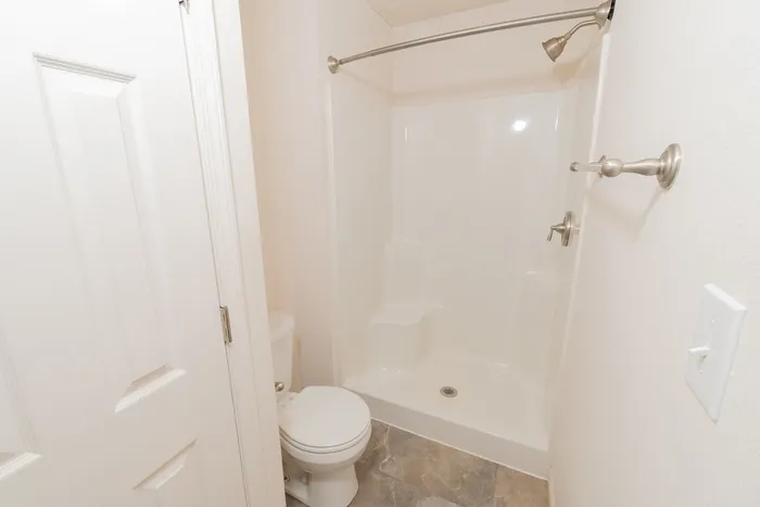 Full bathroom at Quail Ridge East Apartments with tub and shower combination, updated fixtures, towel bar, and durable flooring.