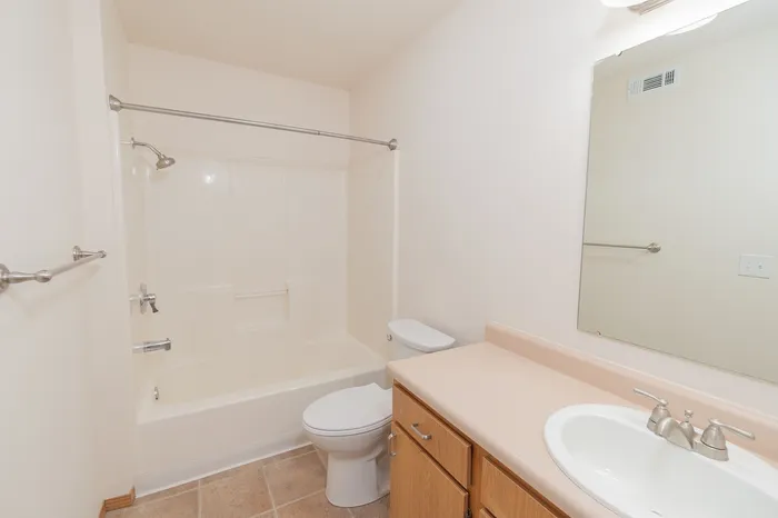 Bright and modern bathroom with elegant fixtures, bathtub, and ample counter space.