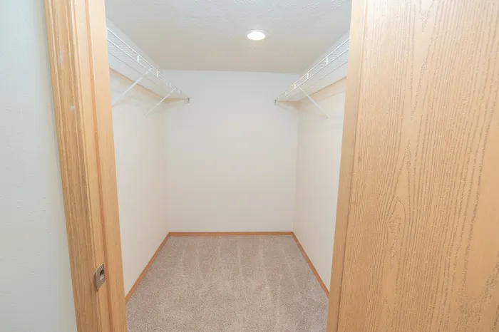 Spacious walk-in closet with ample shelving, perfect for organizing your wardrobe.