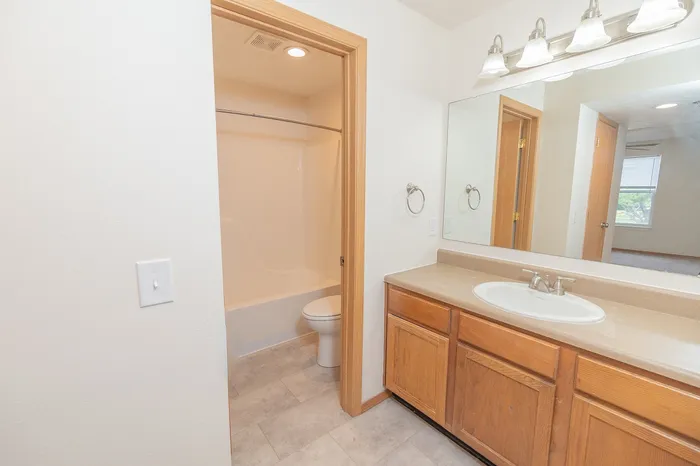 Bright and inviting bathroom with modern fixtures, featuring a spacious vanity and conveniently integrated shower.