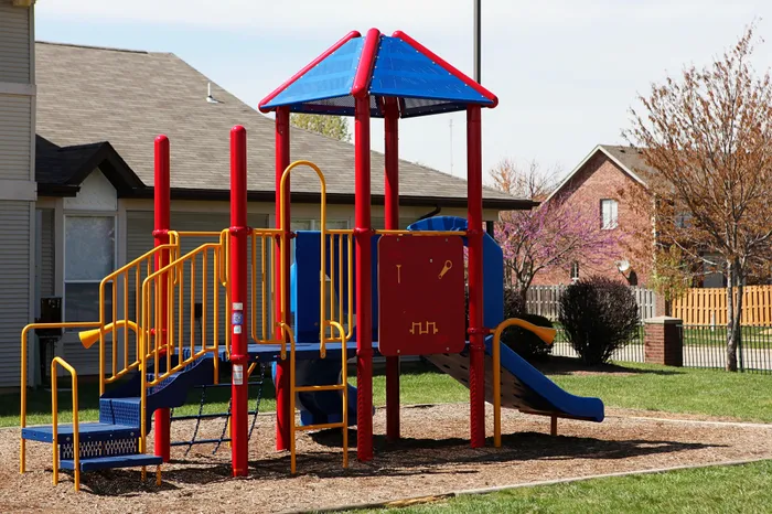 Charming residential playground with vibrant slides and climbing equipment, perfect for community family fun.