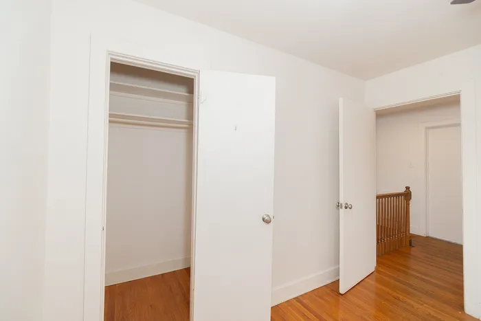 Inviting closet space with elegant wooden flooring and pristine white doors, perfect for stylish storage solutions.