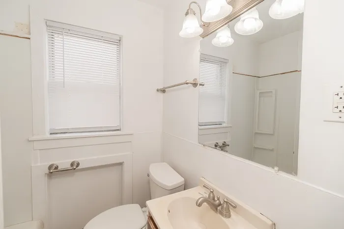Bright and inviting bathroom with modern fixtures, featuring a sleek vanity and elegant lighting.