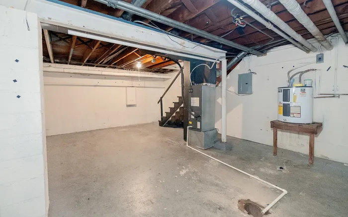 Spacious unfinished basement with exposed beams, ideal for customization and storage solutions.