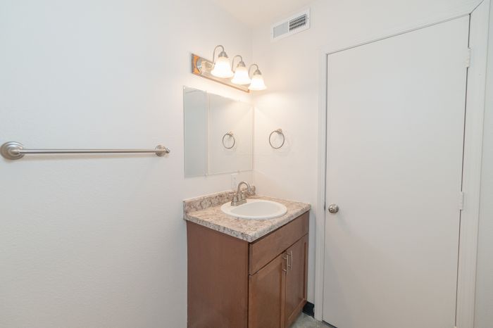 Chic bathroom with elegant lighting, sleek countertop, and modern fixtures offering a serene and functional space.