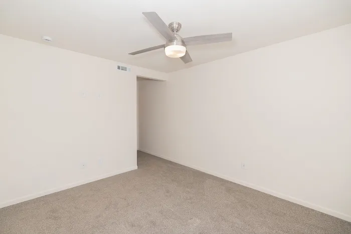 Renovated Chesterfield Village bedroom with gray carpet, a modern ceiling fan, neutral walls, and an open entryway.