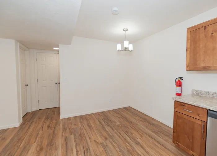 Dining area in a renovated Chesterfield Village apartment with wood look flooring, modern lighting, and neutral walls.