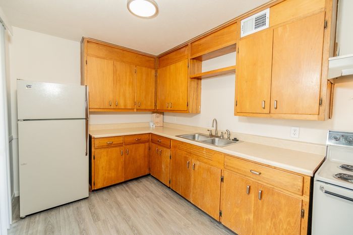 Charming kitchen with natural wood cabinetry, modern appliances, and spacious countertops for an inviting cooking environment.