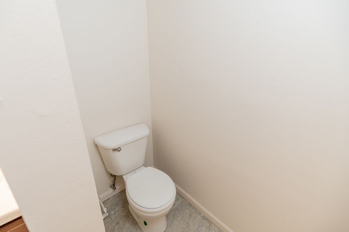 Bright, modern bathroom featuring a pristine white toilet and sleek minimalist walls.