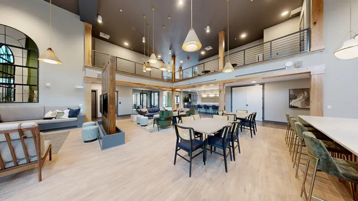 Spacious, modern common area featuring stylish seating, elegant lighting, and a chic loft with contemporary design elements.
