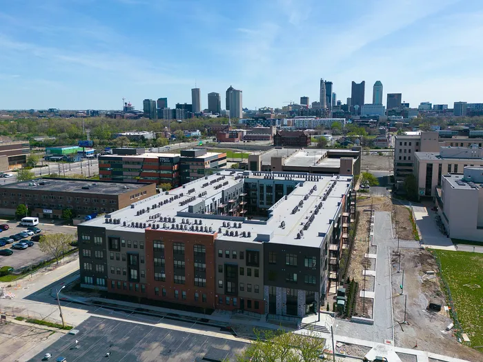 Vibrant urban apartment building with modern architecture, ample parking, and stunning city skyline views.