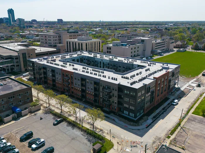 Aerial view of a modern apartment complex showcasing sleek design and urban surroundings, ideal for city living.