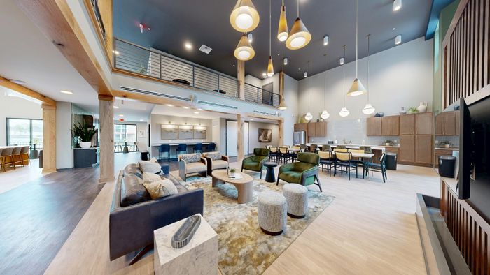 Luxurious open-concept living area with modern furnishings, elegant lighting, and a sleek kitchen bar for entertaining guests.