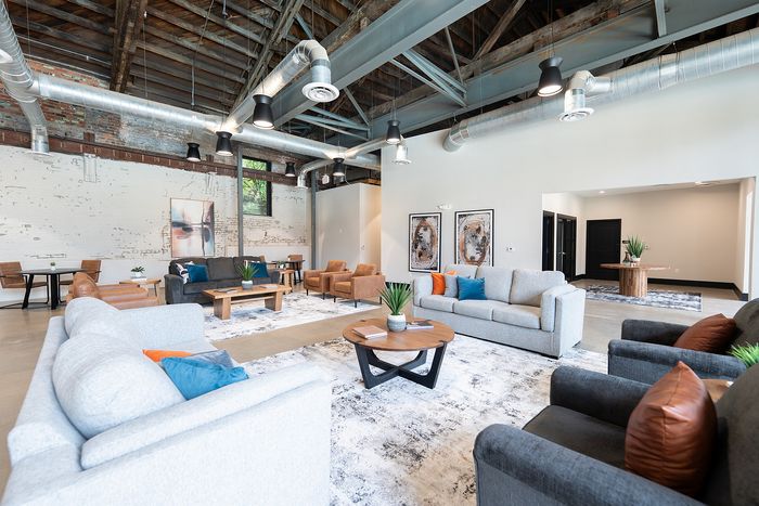 Spacious and stylish open-concept living area with modern industrial design, featuring comfortable seating and artistic decor.