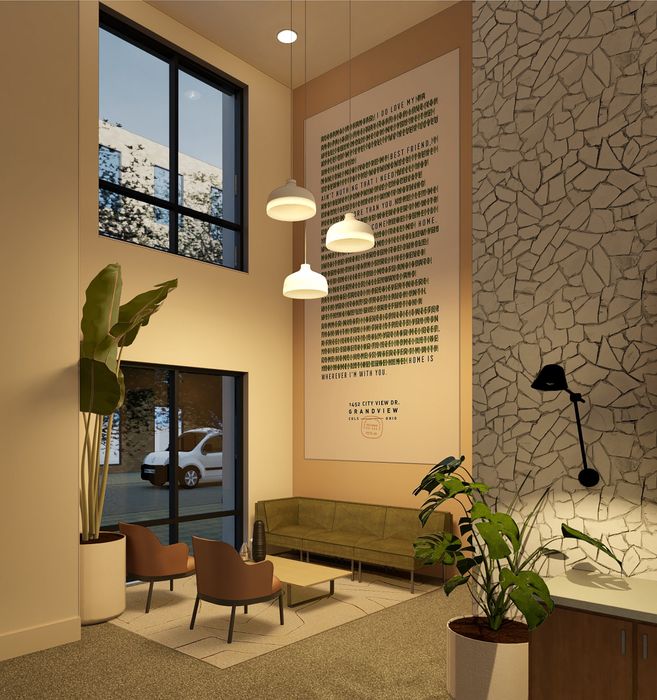 Inviting modern lobby with high ceilings, cozy seating area, decorative wall art, and large windows offering natural light.
