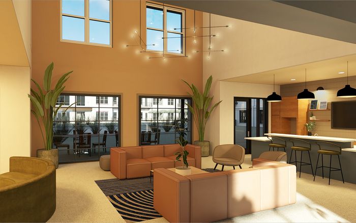 Bright and modern living area featuring elegant sofas, chic pendant lighting, and a contemporary open kitchen with sleek bar seating.