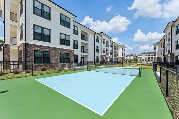 Pickleball court surrounded by white and brown apartment buildings