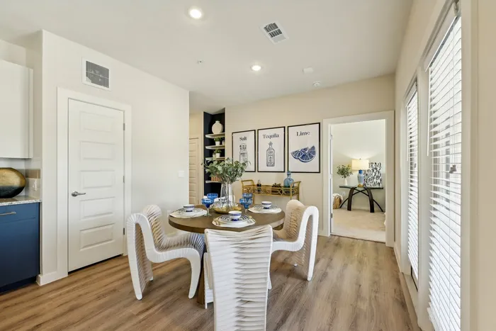 Dining area with a round wooden table and white chairs