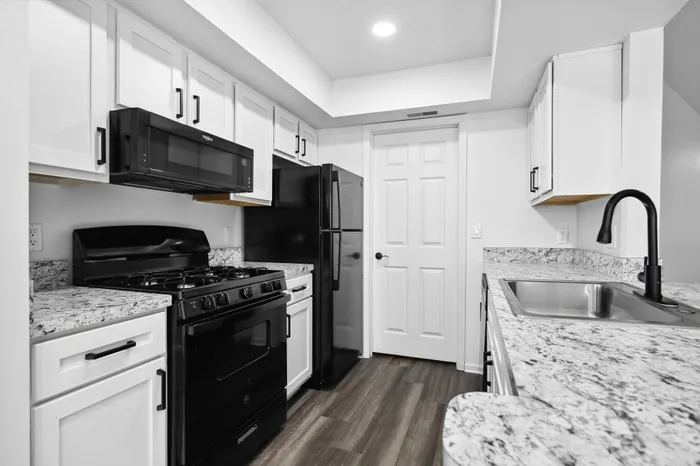 Renovated Apartment - Prep-friendly kitchen with black appliances white cabinetry at  | The Residence at Turnberry | Columbus Apartments
