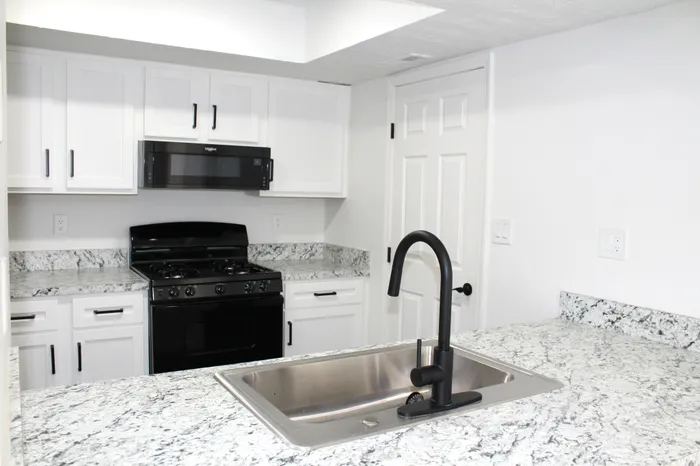 Kitchen - countertops, sink, cabinetry, stove, microwave  | The Residence at Turnberry | Columbus Apartments